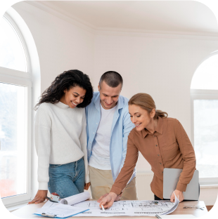 Three people reviewing architectural plans on a desk.