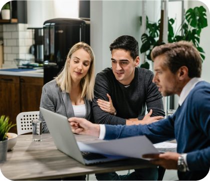 Three business professionals discussing work around a laptop.