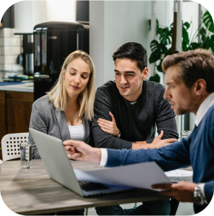 Three business professionals discussing work around a laptop.