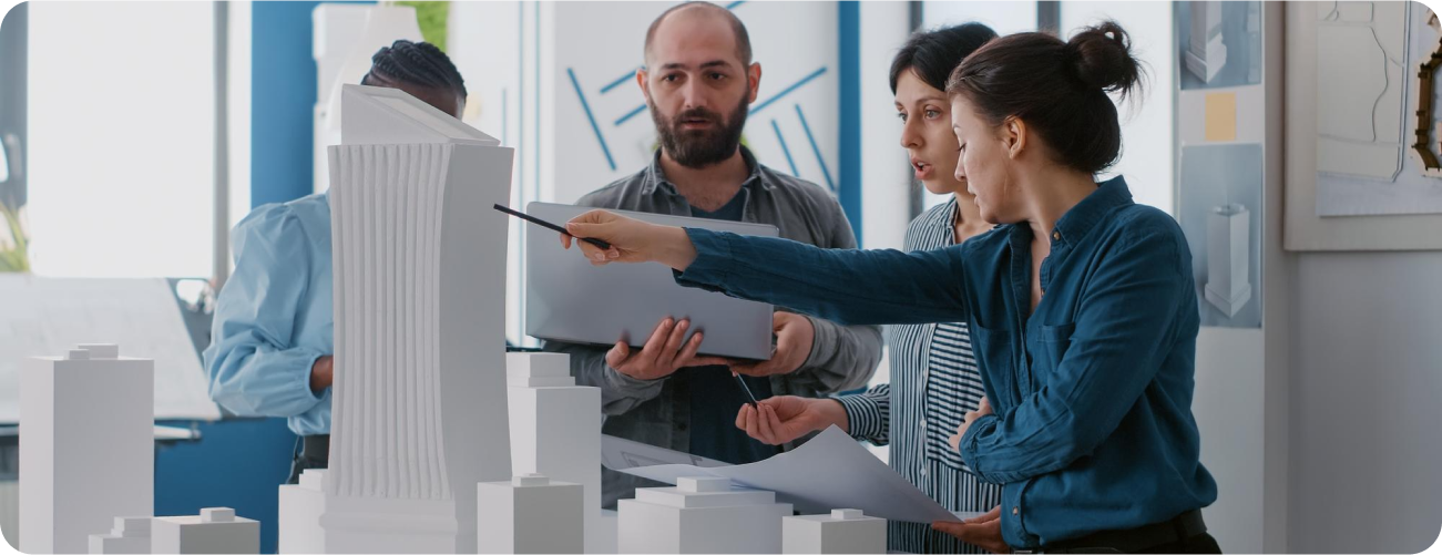 Team of architects discussing around a building model in an office