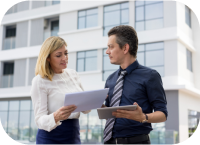 Business professionals reviewing documents outside office building